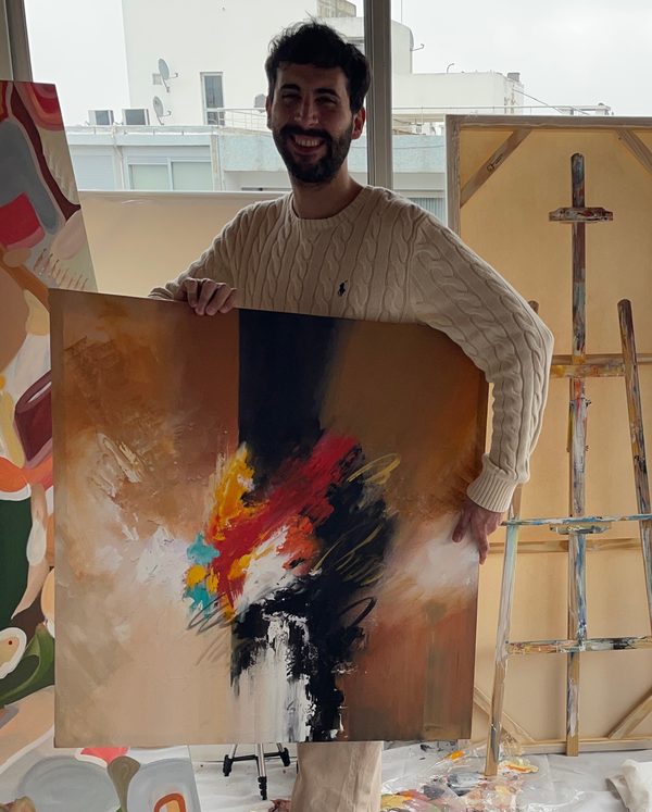Sebastian Zaquiere en su taller, sosteniendo la obra Carmesí.